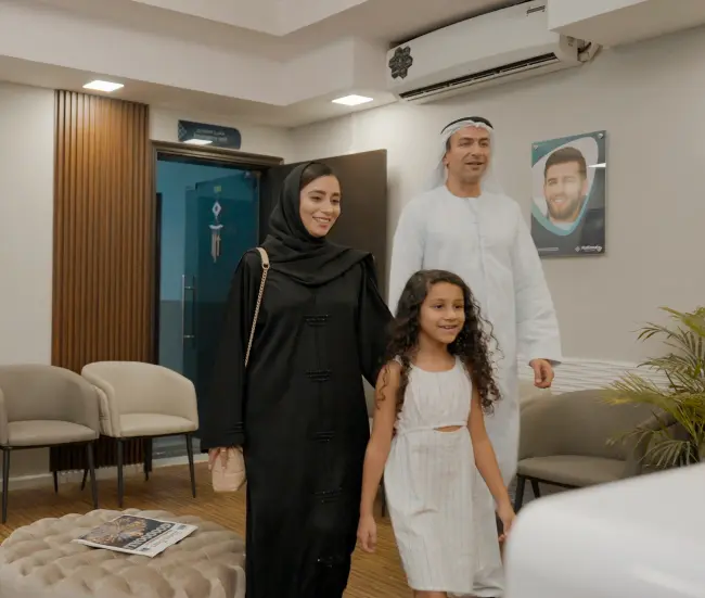 Pediatric dentist examining child patient with empathy and warmth at National Medical Center Dubai